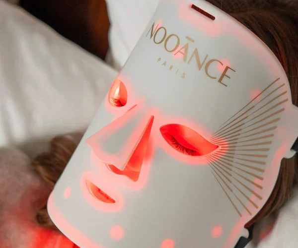 Image représentant une femme allongée portant le masque LED le professionnel de Nooance Paris